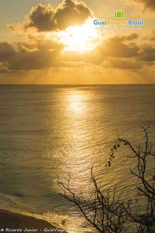 Imagem da luz do sol refletindo nas águas da Praia do Boldro, pôr do sol inesquecível, em Fernando de Noronha, Pernambuco, Brasil.